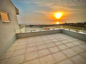 a view of the sunset from the balcony of a building at Breathtaking ocean front studio in Povoa de Varzim in Póvoa de Varzim