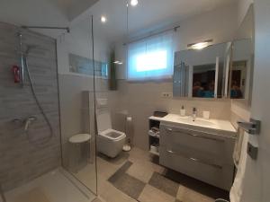 a bathroom with a shower and a sink and a toilet at APARTMAN EDDA **** in Labin +18 photos