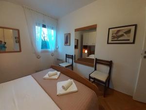 a bedroom with a bed and two chairs and a mirror at APARTMAN EDDA **** in Labin