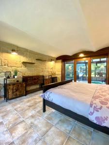 een slaapkamer met een groot bed en een stenen muur bij Apartment Holín in Holín