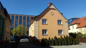 une maison jaune avec une horloge sur son côté dans l'établissement Villa Lena, à Gdańsk