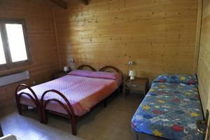 a bedroom with two beds in a wooden cabin at Holiday Home Bagnara in Nocera Umbra