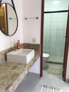 a bathroom with a sink and a toilet and a mirror at Pousada Bonita do Gostoso in São Miguel do Gostoso