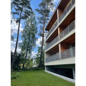 an exterior view of a building with trees at Lipno Port Apartment C101 in Lipno nad Vltavou