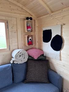 Habitación pequeña con sofá en una cabaña en Ontwaken tussen de paarden, en Helen-Bos