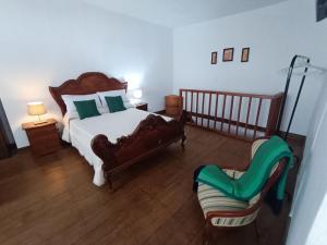 1 dormitorio con 1 cama grande y 1 silla en Vivienda Vacacional Villatajace, en Tajace de Abajo