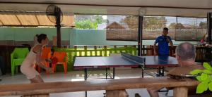 - un groupe de personnes autour d'une table de ping-pong dans l'établissement Pinaluyan Guest House, à Puerto Princesa