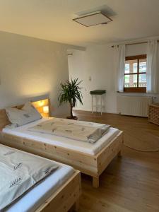 a bedroom with two beds and a potted plant at Ferienwohnung Hofleben Reiner in Neukirchen vorm Wald