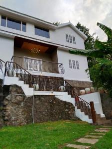 une maison blanche avec des escaliers en face de celle-ci dans l'établissement INN THE MOUNTAIN'S, à Kodaikānāl