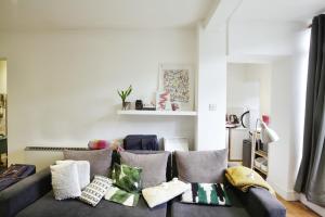 ein Wohnzimmer mit einem Sofa und Kissen in der Unterkunft Charming West London Studio Your Urban Oasis in London
