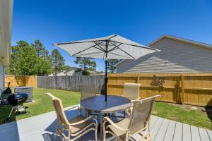 a table and chairs with an umbrella on a deck at Updated Hubert Vacation Rental 5 Mi to Beaches! in Swansboro