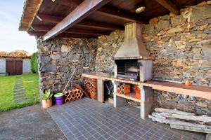 un muro in pietra con forno all'aperto su un patio di Villa Montemar a Calheta