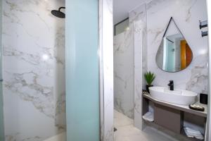 un baño con lavabo y espejo en G & E Apartment, en Kissamos 18 fotos más