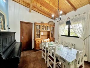 uma sala de jantar com uma grande mesa de madeira e cadeiras em La Casa del Piano - 5831 em Isla