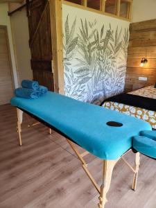 a blue bench in a room with a bed at Le Grenier - Chambre d'hôtes 