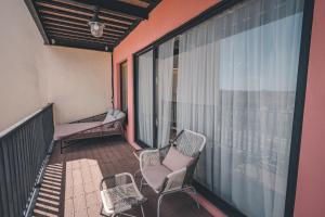 a balcony with chairs and windows on a building at Summer Delight B&B in Nanwan