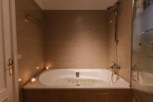 a bathroom with a tub with candles in it at Hostel Los Amigos Yoga & Wellness in La Mareta