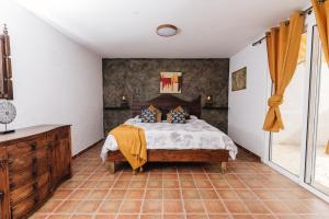 a bedroom with a large bed and a dresser at Hostel Los Amigos Yoga & Wellness in La Mareta