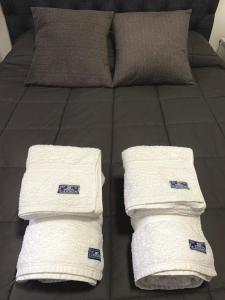 2 witte handdoeken op een bed bij El Condor Fueguino in Ushuaia