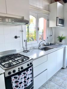 a white kitchen with a stove and a sink at El Condor Fueguino in Ushuaia