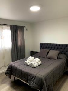 een slaapkamer met een bed met handdoeken erop bij El Condor Fueguino in Ushuaia
