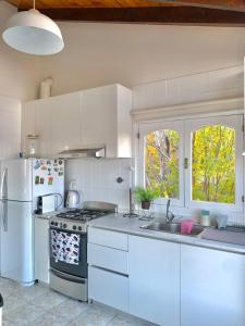 een witte keuken met een fornuis en een koelkast bij El Condor Fueguino in Ushuaia