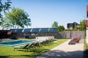 a swimming pool with chairs and a boat in a yard at Pensiunea Casa Porojan in Baile Unu Mai