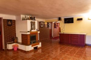 a living room with a brick fireplace and a tv at Pensiunea Casa Porojan in Baile Unu Mai