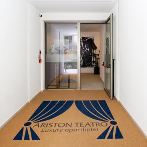 um corredor com uma entrada para um museu com uma porta de vidro em Ariston Teatro Luxury Aparthotel em Grado
