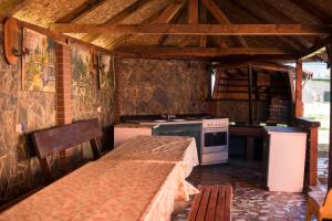 a kitchen with a stove and a table in it at Pensiunea Casa Porojan in Baile Unu Mai