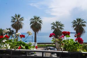 uitzicht op de oceaan met palmbomen en bloemen bij Casa Marina in Milazzo