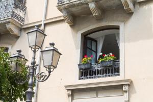 ein Straßenlicht und ein Fenster mit Blumen drauf in der Unterkunft Casa Marina in Milazzo