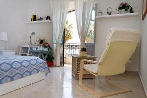een slaapkamer met een stoel, een bed en een bureau bij Casa Marina in Milazzo