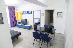 um quarto com uma mesa e cadeiras e um quarto em Summerland Happy Blue Apartments em Mamaia