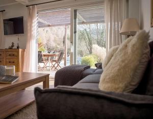ein Wohnzimmer mit einem Sofa und einer Glasschiebetür in der Unterkunft Venez Chez Vous - Le Cocon du Parmelan in Nâves-Parmelan