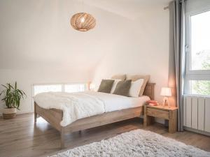 ein weißes Schlafzimmer mit einem großen Bett und einem Fenster in der Unterkunft Venez Chez Vous - Le Cocon du Parmelan in Nâves-Parmelan