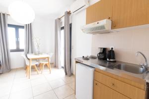 a small kitchen with a sink and a table at Olga Studios in Kokkini Khanion