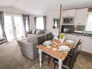 a living room with a dining table and a kitchen at Rose Lodge in Saltburn-by-the-Sea