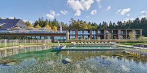 a house with a pond in front of it at Hotel Munde in Hofstetten