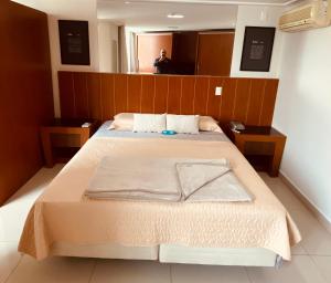 sypialnia z dużym łóżkiem z drewnianym zagłówkiem w obiekcie Fabulosa Suite 903 em Flat Alto Padrão w mieście Londrina