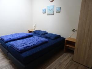 sypialnia z łóżkiem z niebieską pościelą i stołem w obiekcie Kustverhuur, Oude manege Nieuwvliet, Nieuwvliet 1 - 2 w mieście Nieuwvliet