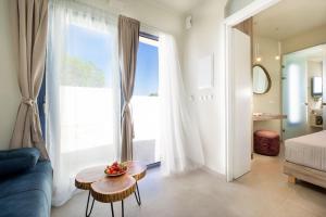 uma sala de estar com um sofá, uma mesa e uma janela em Villa Makisland With Sea View em Stavros