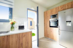 uma cozinha com um frigorífico de aço inoxidável e uma janela em Villa Makisland With Sea View em Stavros