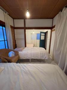 東京にある経堂の小さな一棟貸wakuseiのベッド2台と窓のある寝室