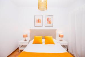a bedroom with a white bed with yellow pillows at Villa Tropical Private Pool Capellania By Holidays Home in La Oliva