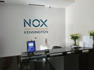 Pokój z biurkiem z telewizorem i znakiem w obiekcie NOX Kensington w Londynie