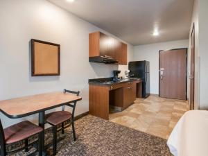 um pequeno quarto com uma mesa e uma cozinha em My Place Hotel-Fargo, ND em Fargo