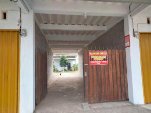 a building with a wooden door and a sign on it at Domen homestay syariah krui 64 in Krui