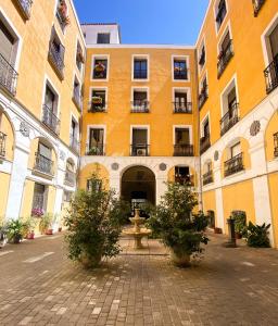 a large yellow building with potted trees in front of it at HOSTAL ANDREA SOL in Madrid