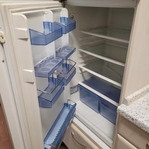 an empty refrigerator with blue plastic bins in it at Ludwigsturm Appartement in Straubing in Straubing